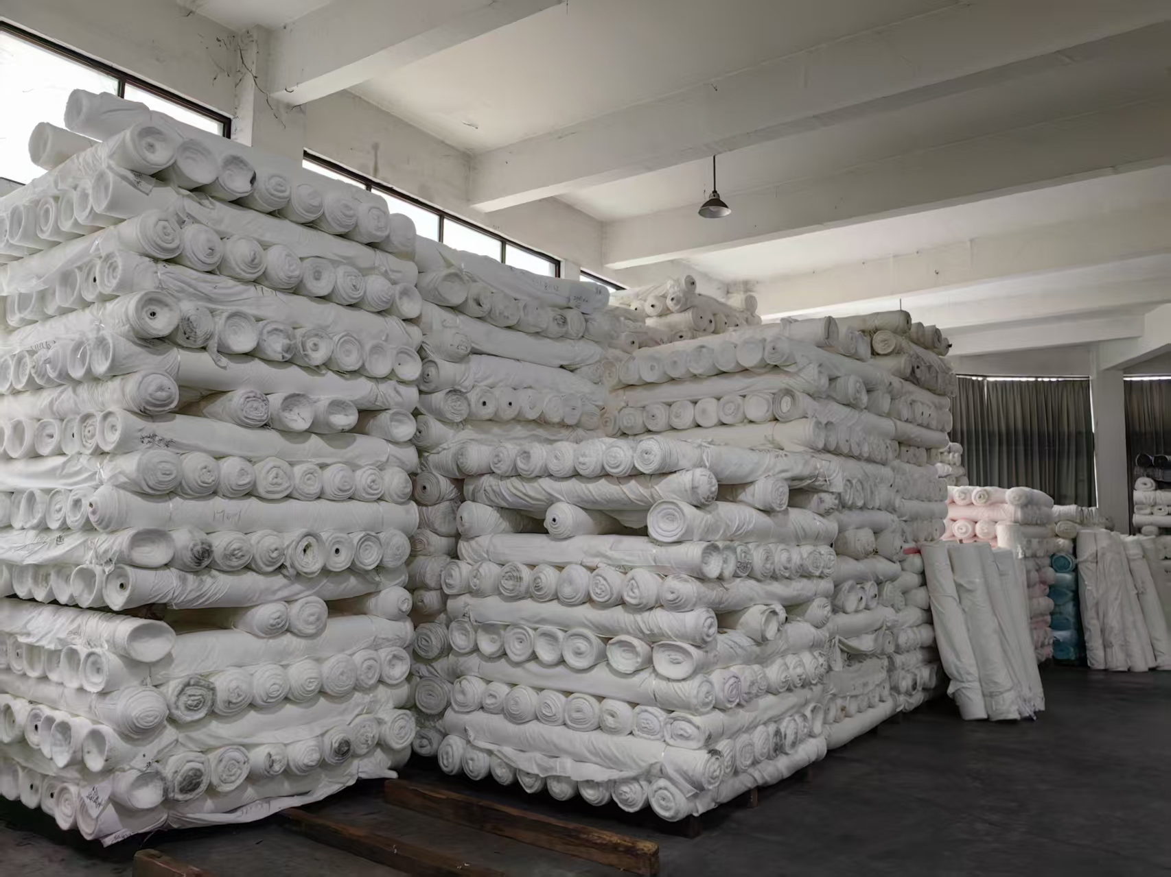 Rows of grey fabric reserves at 푸싱 텍스타일