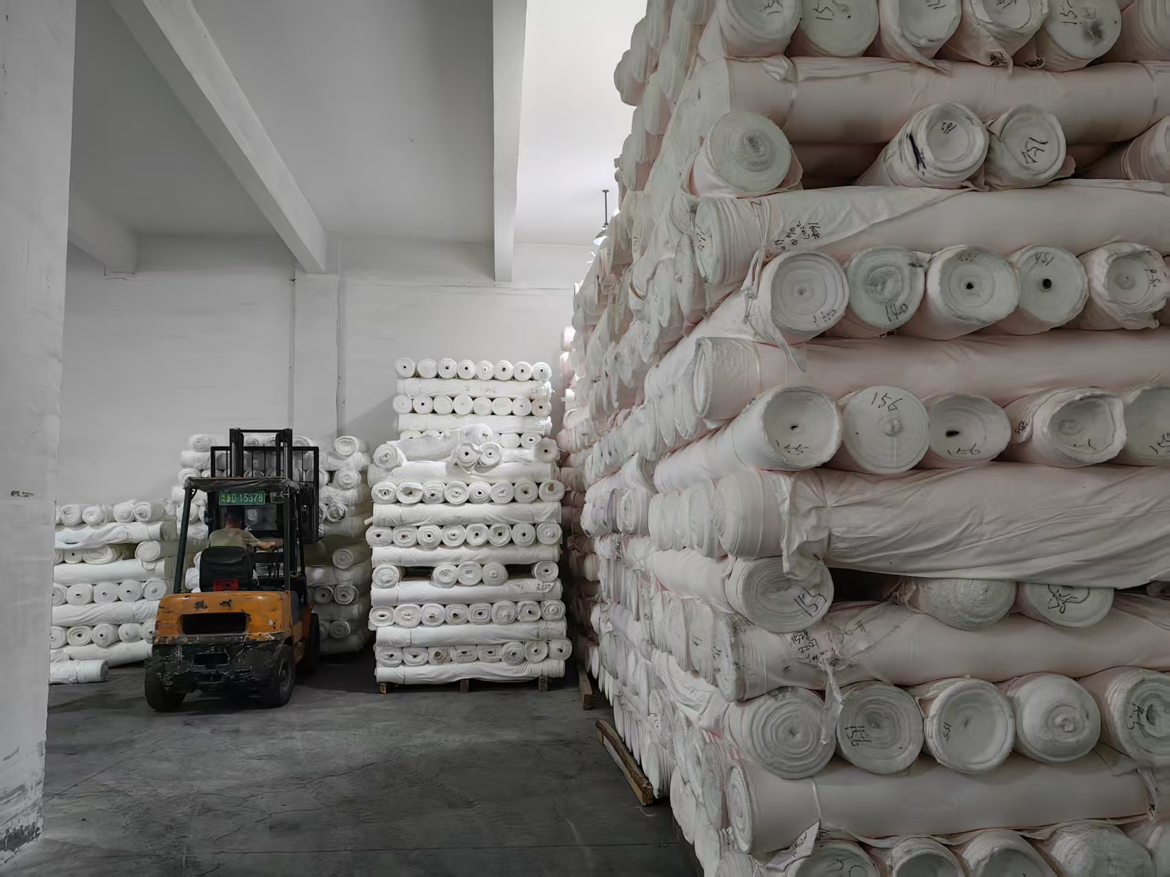 Grey fabric bolts stacked in the 푸싱 텍스타일 grey fabric warehouse