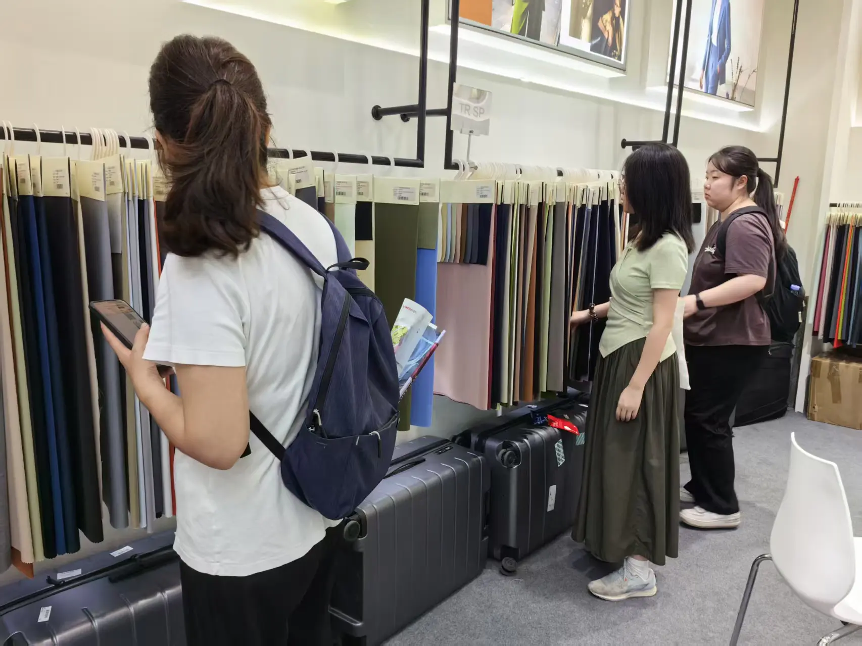Visitor checking wool fabric rack at the 푸싱 텍스타일 booth